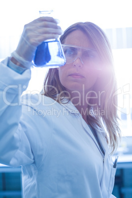 Scientist holding up beaker of chemical