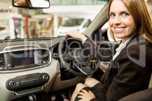 Smiling businesswoman siting in a car