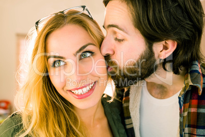 Hipster kissing his pretty colleague