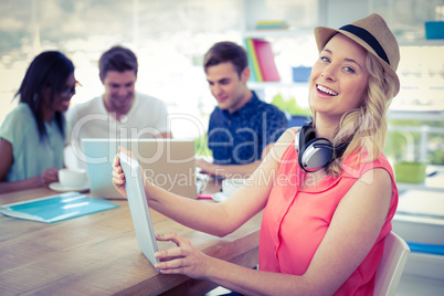 Smiling creative businesswoman working with co-workers