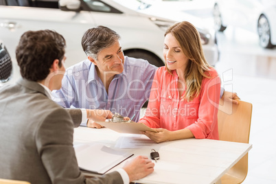 Smiling couple buying a new car