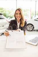 Smiling saleswoman holding a clipboard