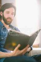 Casual man reading on his sofa