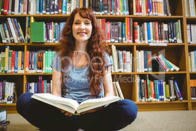 Mature student reading book in library