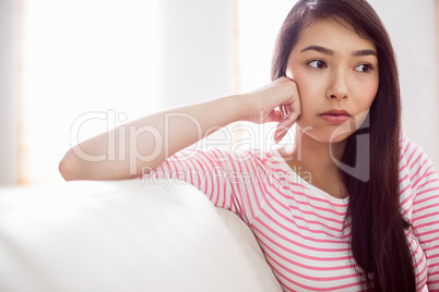 Upset asian woman on couch