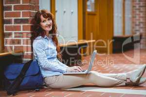 Mature student using laptop in hallway