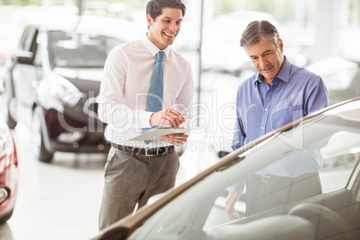 A man showing a car to the salesman A man showing a car to the salesman