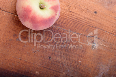 Peach on wooden plate