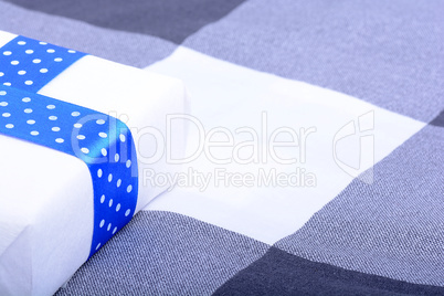 White gift box with blue ribbon