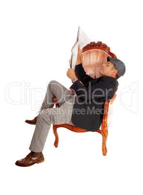 Man sitting in armchair reading paper.