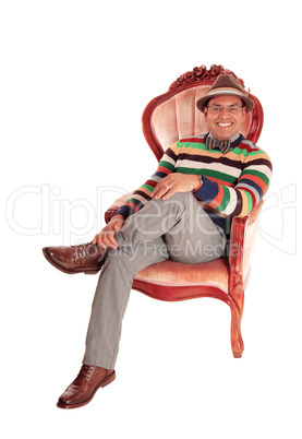 Smiling middle age man in armchair.