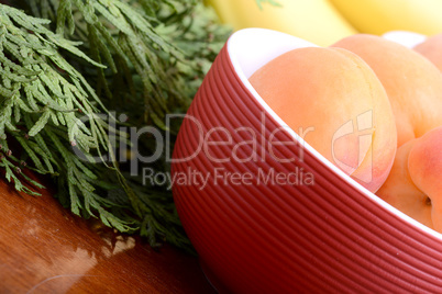 bananas and apricots on red plate, close up