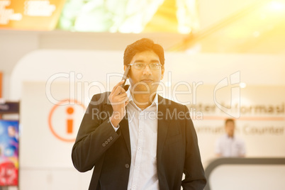 Indian businessman walking by information counter