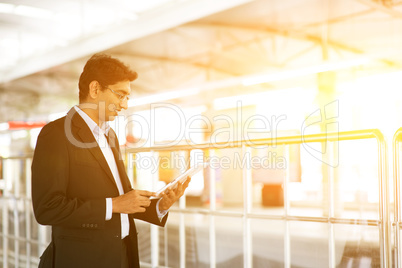 Businessman using tablet computer at railway station