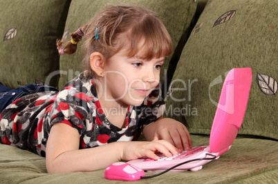 little girl typing on laptop