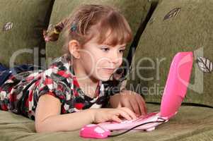 little girl typing on laptop