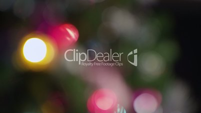 Defocused closeup Christmas tree with colorful flashlights