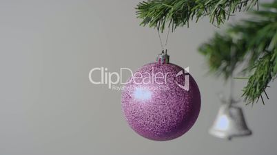 Purple Christmas ball and silver bell on the Christmas tree branch