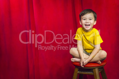 Laughing Boy Sitting on Stool in Front of Curtain