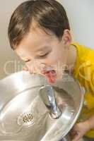 Mixed Race Boy Drinking From the Water Fountain