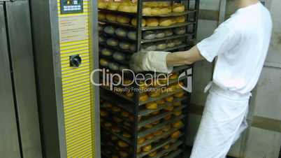 german baker pull different roll buns from the oven 11684