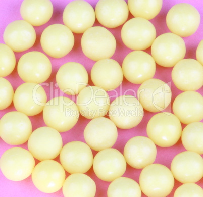 yellow vitamins on pink background