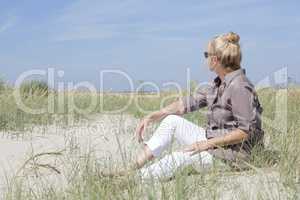 Urlauberin sitzt am Strand