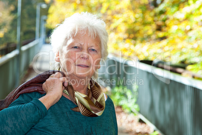 Seniorin enjoys the outdoors in autumn park