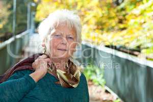 Seniorin enjoys the outdoors in autumn park
