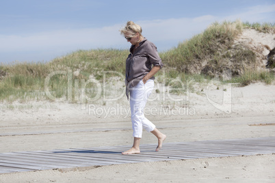 Urlauberin spaziert auf Strandweg