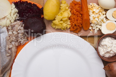 Ingredients for the herring salad with an empty plate
