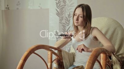 Girl on armchair, rocker with remote control