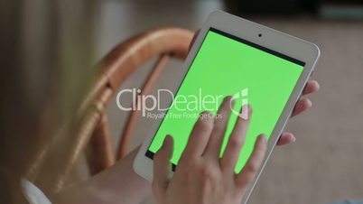 Woman hands touching and scrolling tablet.green screen display