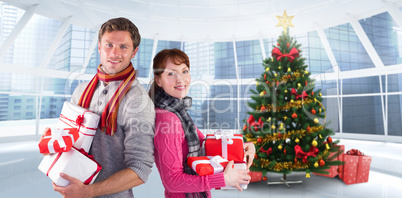 Composite image of couple holding lots of presents