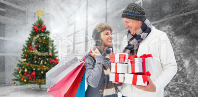 Composite image of festive mature couple holding christmas gifts