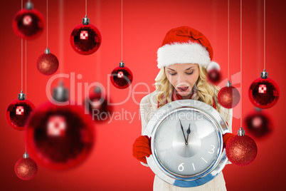 Composite image of happy festive blonde with clock