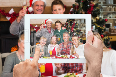 Composite image of hand holding tablet pc