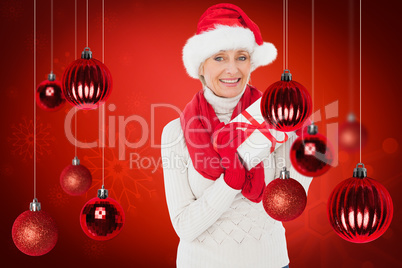 Composite image of festive woman holding gift