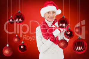 Composite image of festive woman holding gift