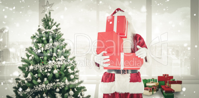 Composite image of santa covers his face with presents