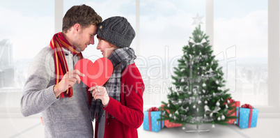 Composite image of couple holding a red heart