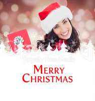 Composite image of joyful brunette presenting christmas gift