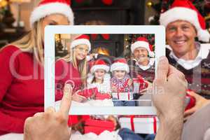 Composite image of hand holding tablet pc