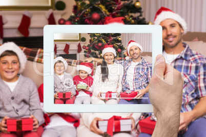 Composite image of hand holding tablet pc