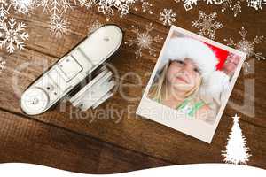 Composite image of girl wearing santa hat at home