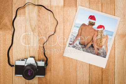 Composite image of rear view of couple sitting on beach