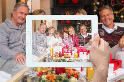 Composite image of hand holding tablet pc