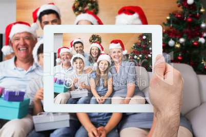 Composite image of hand holding tablet pc