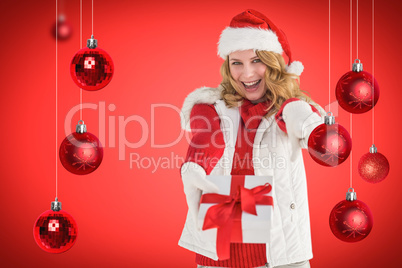 Composite image of festive blonde holding christmas gift and poi