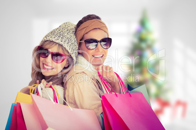 Composite image of beautiful women holding shopping bags looking